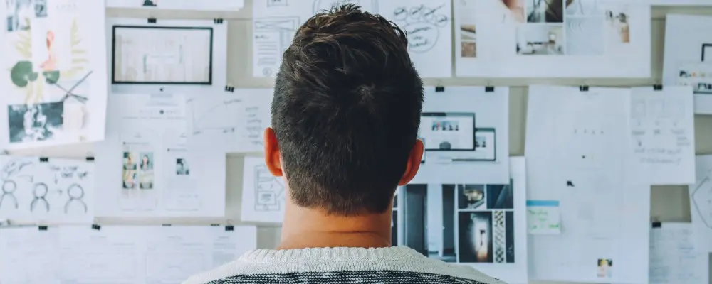 man reviewing a board full of ideas