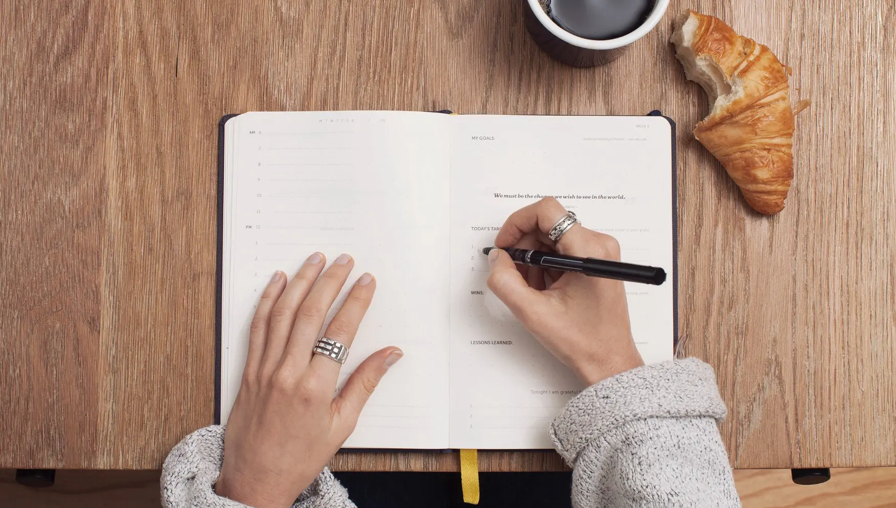 Person writing a to-do list in notebook