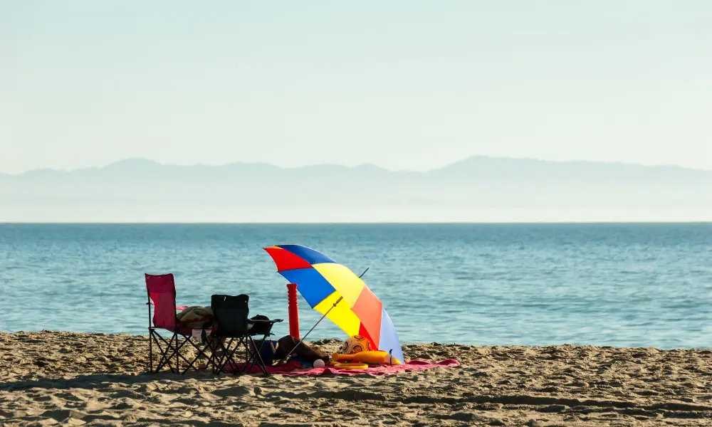 person relaxing on a beach under an umbrella