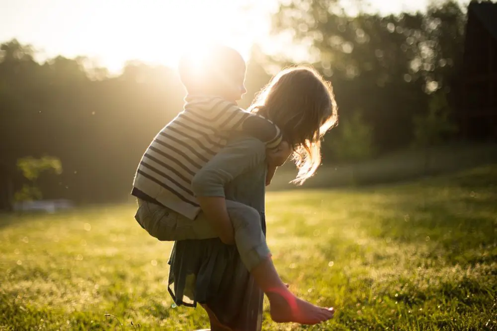 little girl giving a boy a piggy back