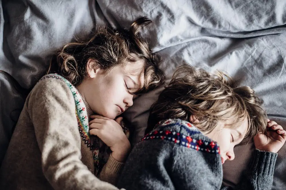 two children resting on a bed