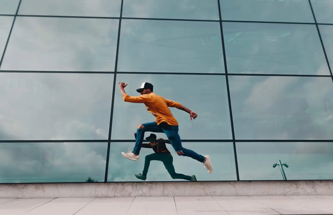 Mann springt vor Gebäude