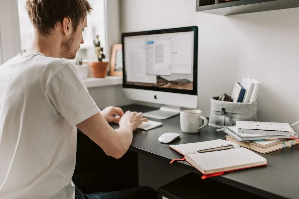 man typing at work desk