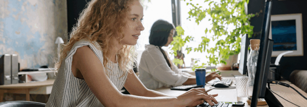 Mitarbeiterin arbeitet konzentriert am Computer im modernen Büro bei der digitalen Aktenführung mit E-Akte